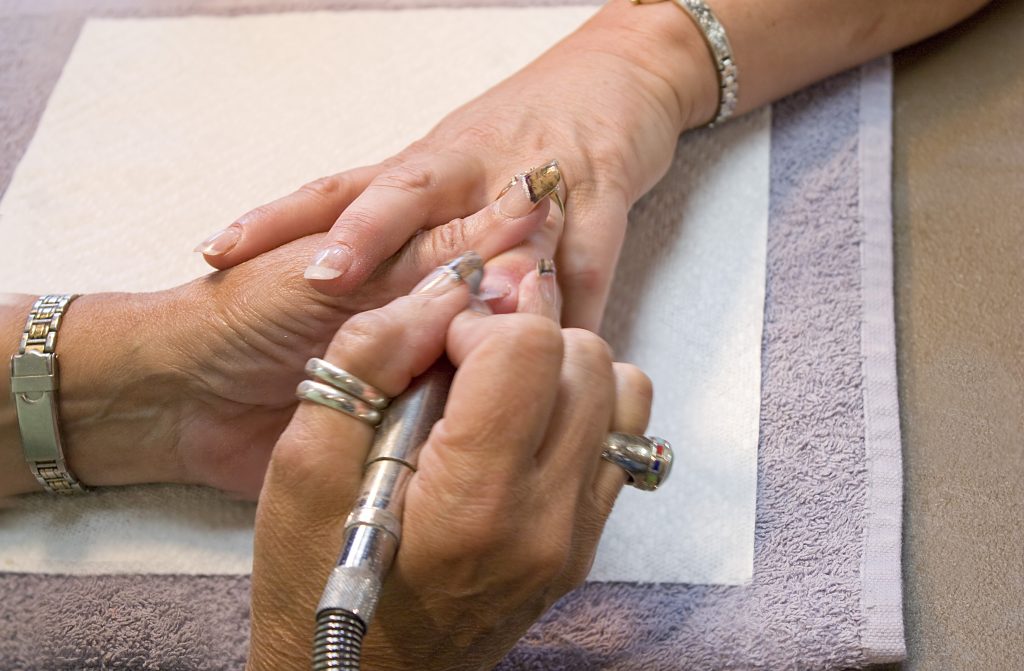 a professional nail technician working on a clients nails BFe0SdCSs