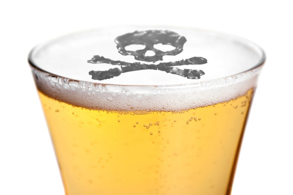 the dangers of alcoholism concept with a skull and cross bones symbol floating on top of the beer BK7 Fi Rrj