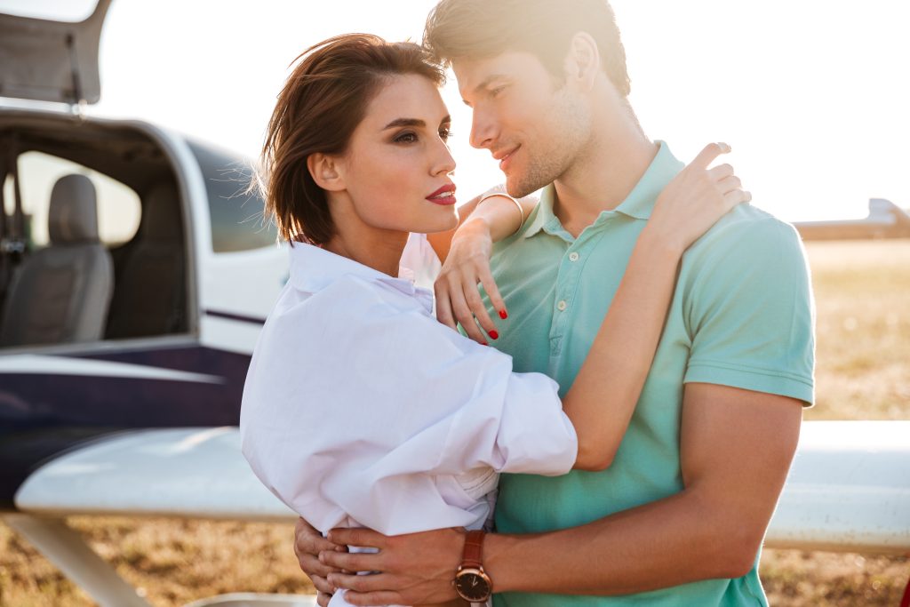 graphicstock beautiful young couple standing and hugging near private aircraft SuNixr B2l
