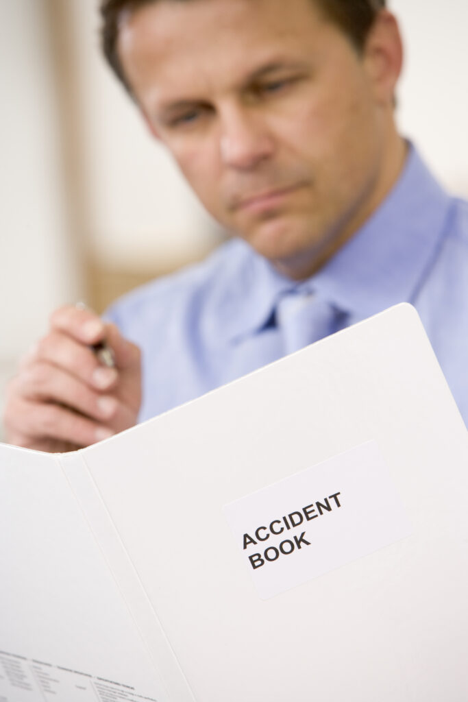 businessman indoors looking at accident book rFKyfTRrj